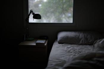 in einem abgedunkelten Raum steht ein gemütliches Sofa am Fenster